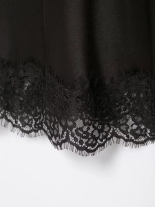 Gros plan sur le satin noir lisse et la bordure en dentelle de cils délicate