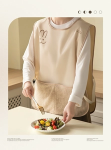 Detail of waterproof beige apron with plush pocket and cute rabbit print for home kitchen