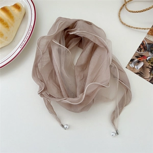 Detail of champagne sheer scarf with white wavy stitching and pearl charm accents