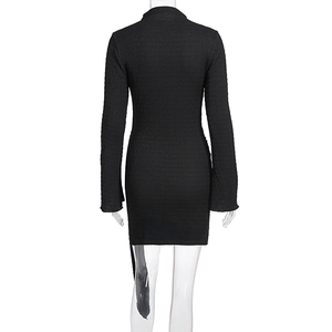 Détail de la robe moulante noire avec tissu plissé texturé et encolure ronde au dos