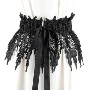 Detail of elegant black lace corset belt featuring leaf patterns and a silk ribbon bow