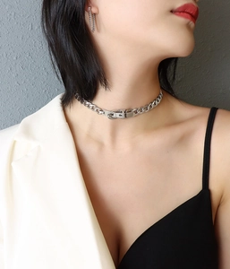Silver buckle choker and matching chain earrings displayed on a professional model