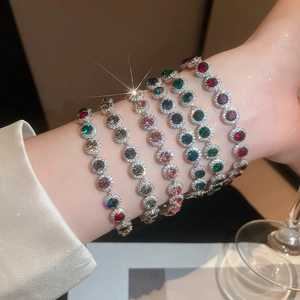 Gros plan de bracelets de luxe empilés avec des pierres colorées et détails en zircon
