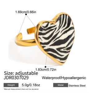 Detailed close-up of golden stainless steel heart ring with zebra pattern inlay