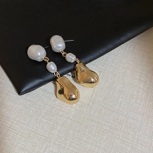 Vue détaillée de boucles d'oreilles en perles baroques avec pendentifs dorés irréguliers