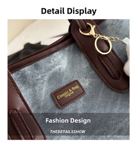 Detail of denim tote bag with brown leather trim and golden logo plaque for casual style