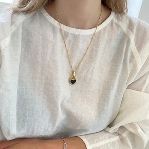 925 silver heart necklace with black inlay and beaded gold chain on model