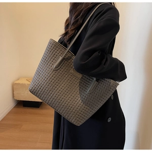Detail of grey woven leather tote bag with sturdy handles for commuting and fashion