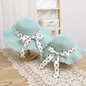 Detail of mint green straw hats for mother and child with polka dot ribbon bows