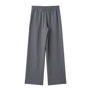 Detail of dark gray wide-leg pants featuring elastic waist and vertical pleated texture