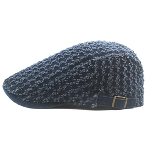 Detail view of adjustable metal buckle on dark blue distressed denim flat cap side