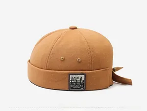Side view of brown retro docker cap showing canvas texture and denim supplies label