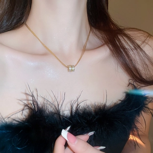Close-up of gold-plated multi-layer zircon cylinder pendant necklace on model's collarbone