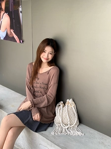 Detail shot of a beige woven tote bag with round wooden handles on a concrete seat