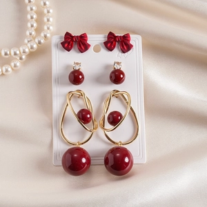 6-piece vintage earring set with red bows and faux pearls on champagne silk fabric