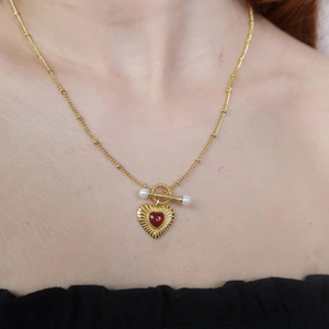 Detail of 18k gold stainless steel necklace featuring red agate heart and white pearls