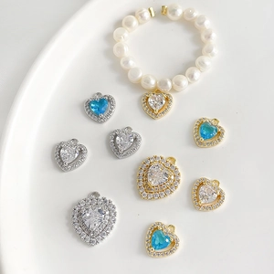 Pendentifs cœur en zircon plaqué or 18k et bracelet perles sur plateau céramique