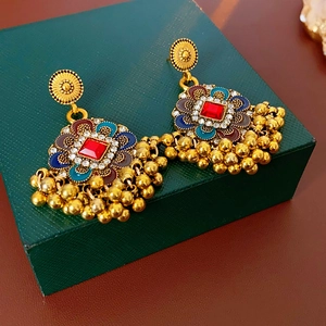 Détails des boucles d'oreilles fleurs vintage avec pierres rouges et pompons dorés