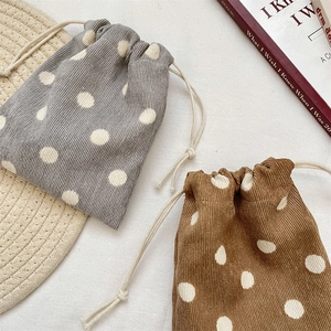 Close-up of gray and brown corduroy drawstring bags with white polka dot patterns