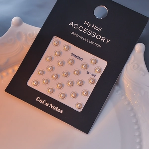 Detail of 5D gold embossed nail stickers with pearls on elegant white ceramic plate