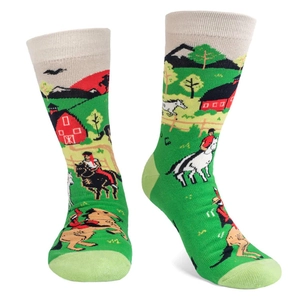 Detail of green knitted socks featuring rural countryside patterns with red barns and horses