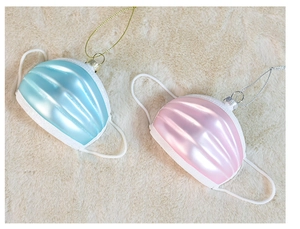 Dettaglio degli addobbi Babbo Natale con mascherina azzurro e rosa su pelliccia color crema