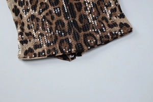 Détail du body à imprimé léopard avec paillettes argentées et fermeture à pression