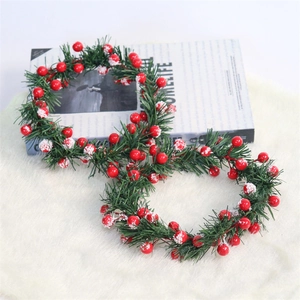 Detail of red berries Christmas wreath with snow effect on soft white plush rug