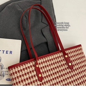 Detail of red houndstooth tote with leather long straps and gold rivet accents