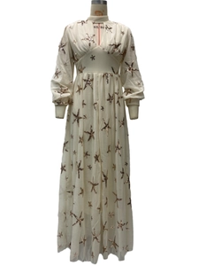 Detailed view of cream chiffon dress with golden star sequins and high collar design