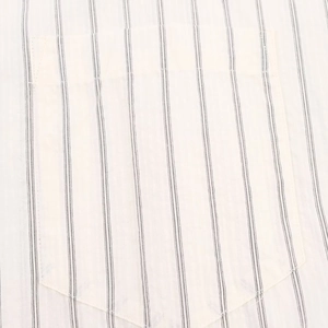 Detail shot of black stripes on an off-white cotton shirt with a focus on the front pocket