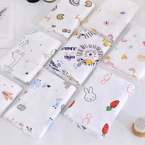 Flat lay of multiple folded cotton baby swaddle blankets with cute cartoon animal prints