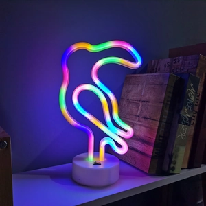 Rainbow LED toucan neon light with white base on bookshelf for cozy room decoration