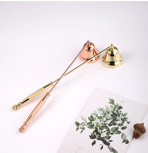 Detailed view of bell-shaped candle snuffers in gold and rose gold metal finishes