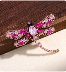 Close-up of pink crystal dragonfly brooch with golden alloy wings and vintage details