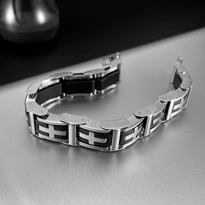 Macro detail of men's stainless steel and black silicone bracelet with cross patterns