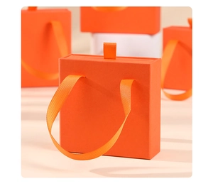 Detail of vibrant orange jewelry drawer box with matching silk ribbon pull handle