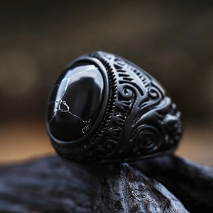 Dettaglio macro di un anello vintage da uomo in acciaio nero con pietra ovale nera