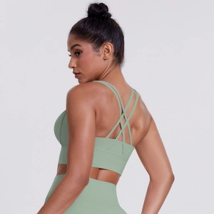 Detail of mint green yoga bra showing multi-strap cross back design and matte fabric texture
