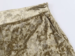 Detail of olive velvet lantern pants featuring silver floral print and invisible zipper