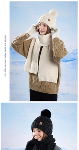 Close-up of winter knit set including a thick beanie with pompom, scarf and gloves