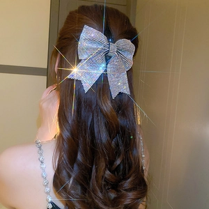 Sparkling rhinestone bow hair clip shown on back of head for an elegant hairstyle