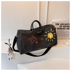 Detail of black matte travel bag with colorful sun and plane graffiti patterns