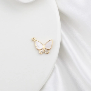 Macro shot of 18k gold butterfly pendant with mother of pearl and zircon details
