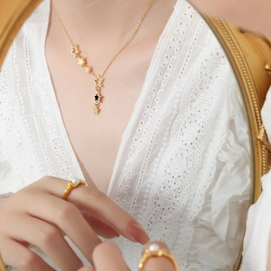 Elegant gold-plated star necklace and pearl ring set on model with soft lace background
