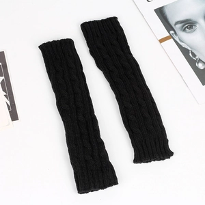 Detailed view of black cable knit arm warmers made of thick acrylic yarn for winter