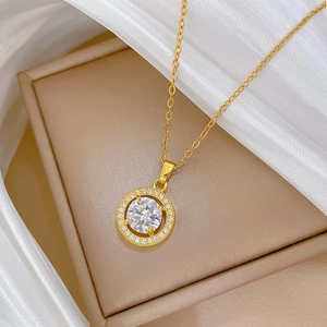 Close-up of gold titanium steel necklace with circular zircon pendant on jewelry box