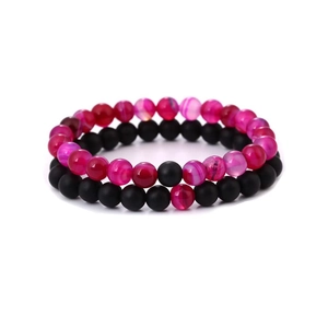 Detail of pink striped natural stone and matte black beads on elastic bracelets
