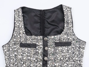 Detail of tweed dress with silver sequins, black piping, and decorative buttons