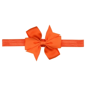 Detail of soft ribbed ribbon bow and elastic headband in bright coral orange color
